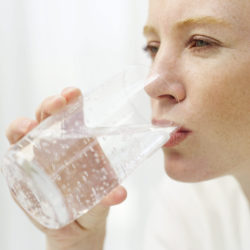 グラスで水を飲む女性
